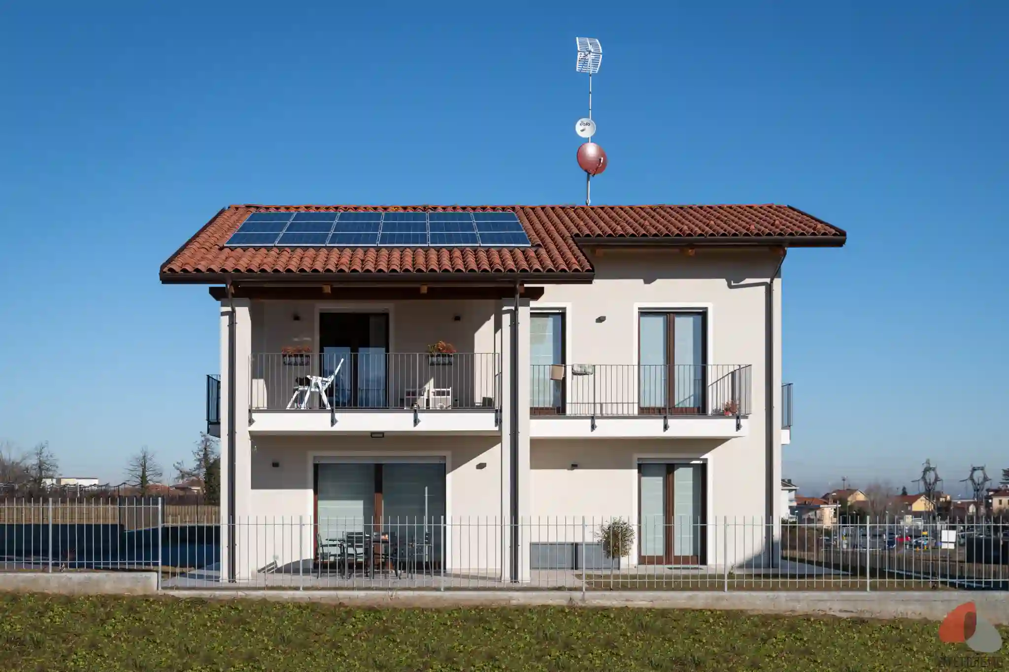 vista frontale di casa unifamiliare moderna con tetto a falde e impianto fotovoltaico integrato