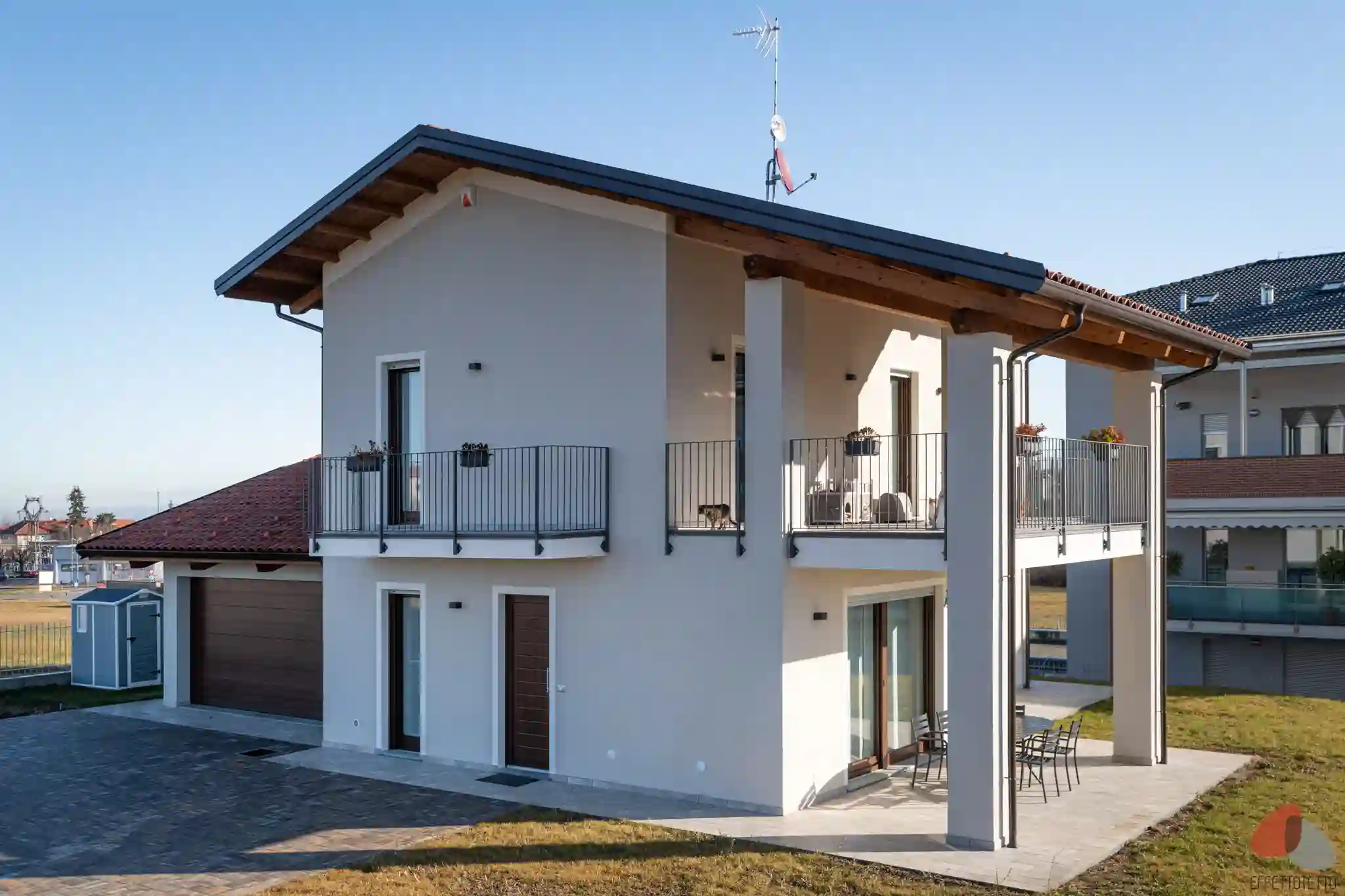 vista angolare di abitazione indipendente con portico, balconi e finiture contemporanee
