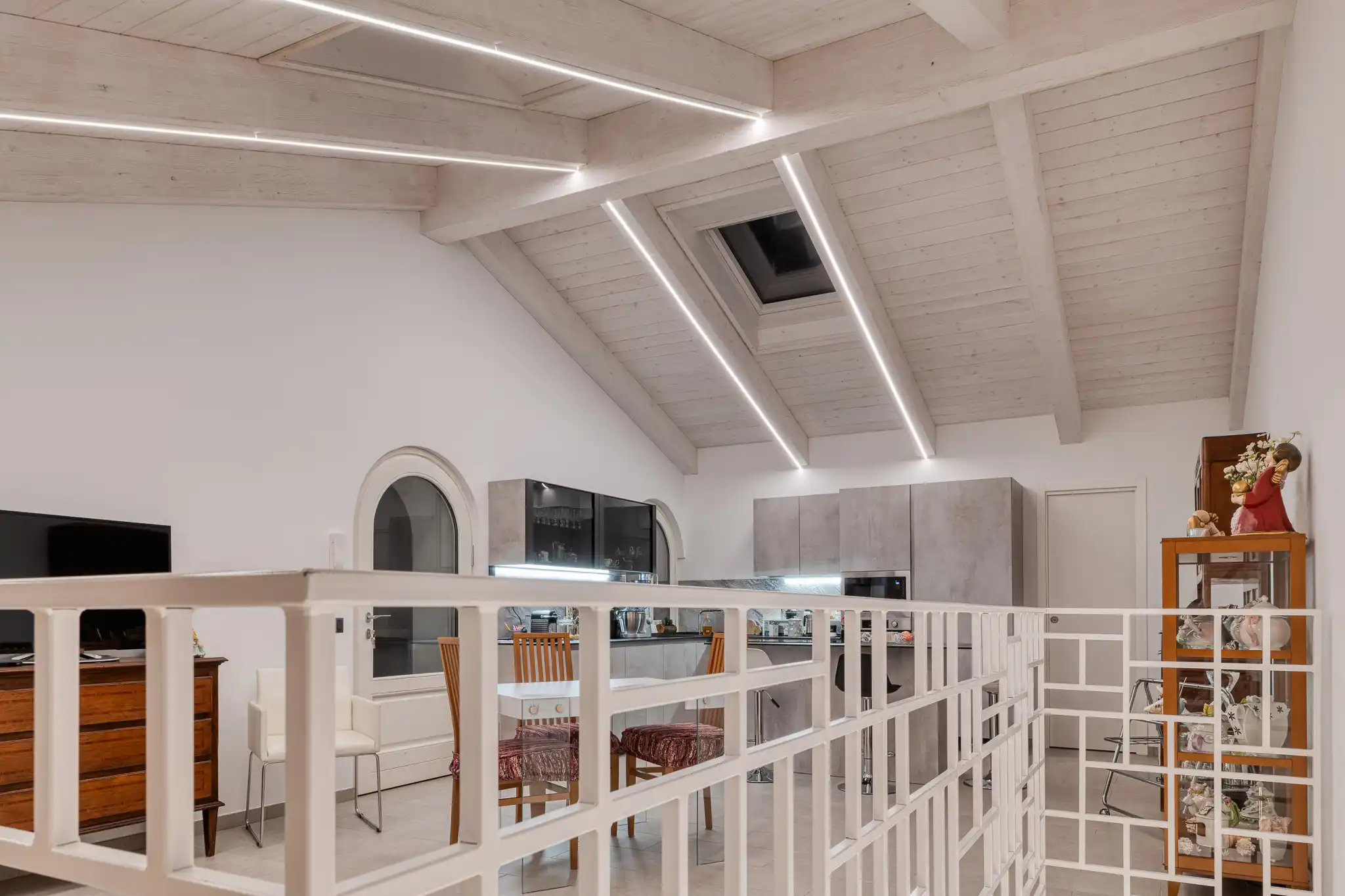 open space con cucina moderna con tetto in legno a vista con lucernario
