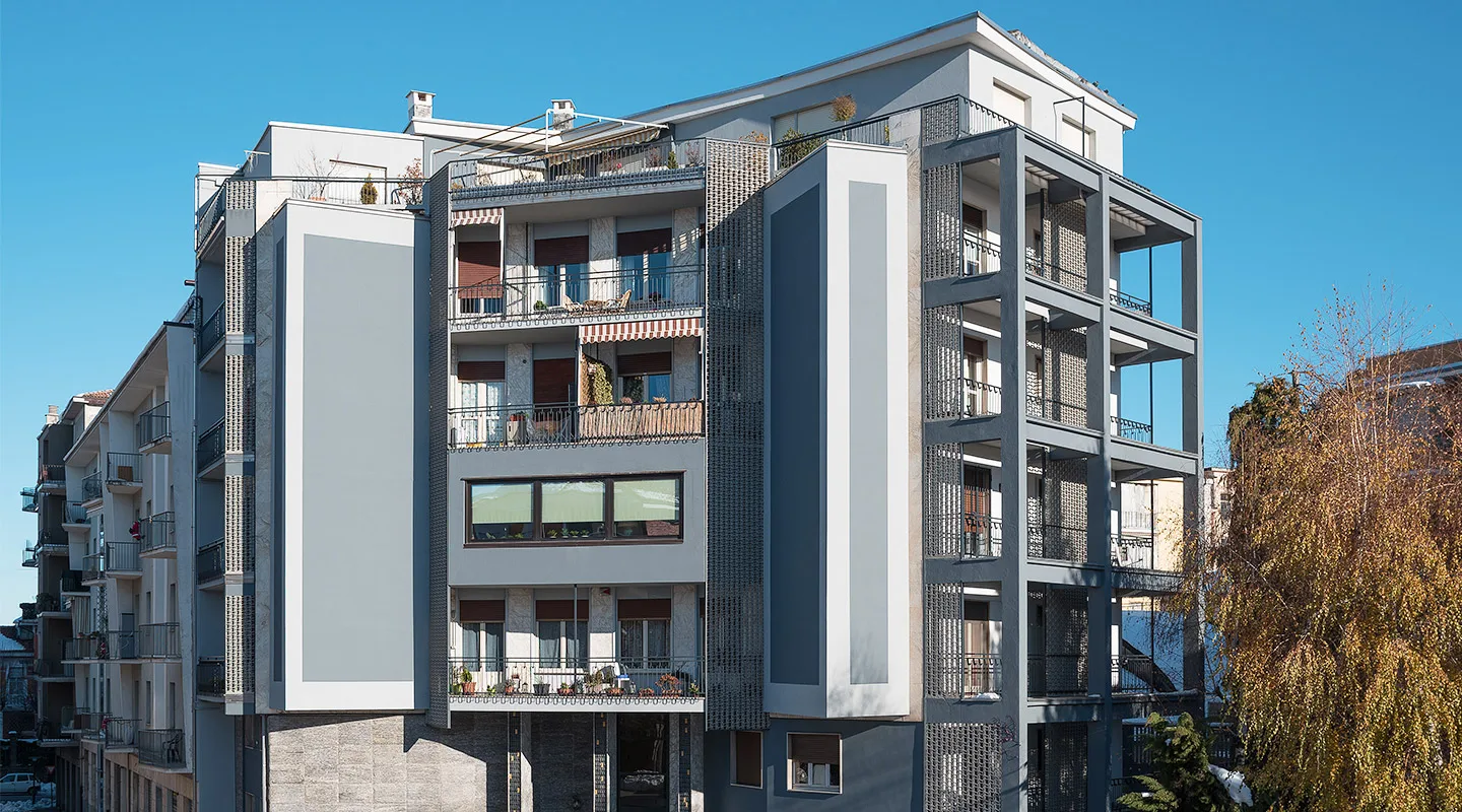 condominio riqualificato con rivestimenti in pietra e volumi architettonici definiti