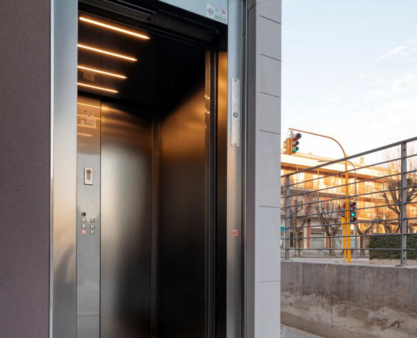 03_immagine_progetto_doga_vertigo cabina di ascensore con porta aperta e illuminazione interna moderna in edificio residenziale