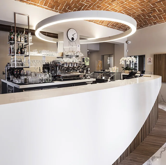 03_immagine_progetto_la_chiocciola_degli_angeli bancone bar bianco curvo con macchina del caffè professionale e soffitto a volta