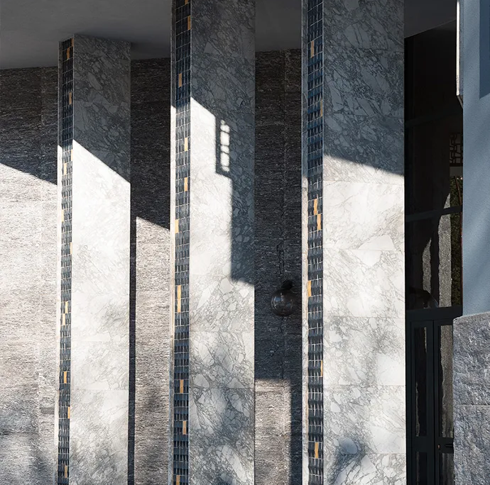 03_immagine_progetto_v_lotto pilastri portanti all'ingresso dell'edificio rivestiti con mosaico scuro e piccoli inserti dorati