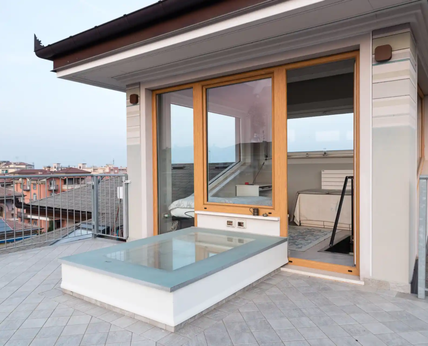 04_immagine_progetto_cielo_recuperato vista dal terrazzo esterno sulla copertura a mansarda con le nuove finestre per tetti
