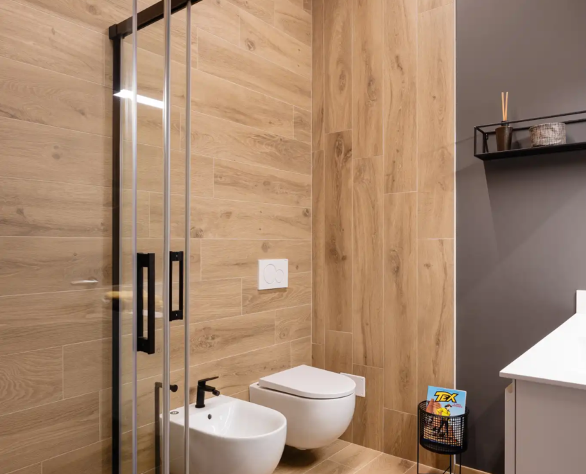 bagno dal design contemporaneo con piastrelle effetto legno, doccia walk-in e sanitari sospesi
