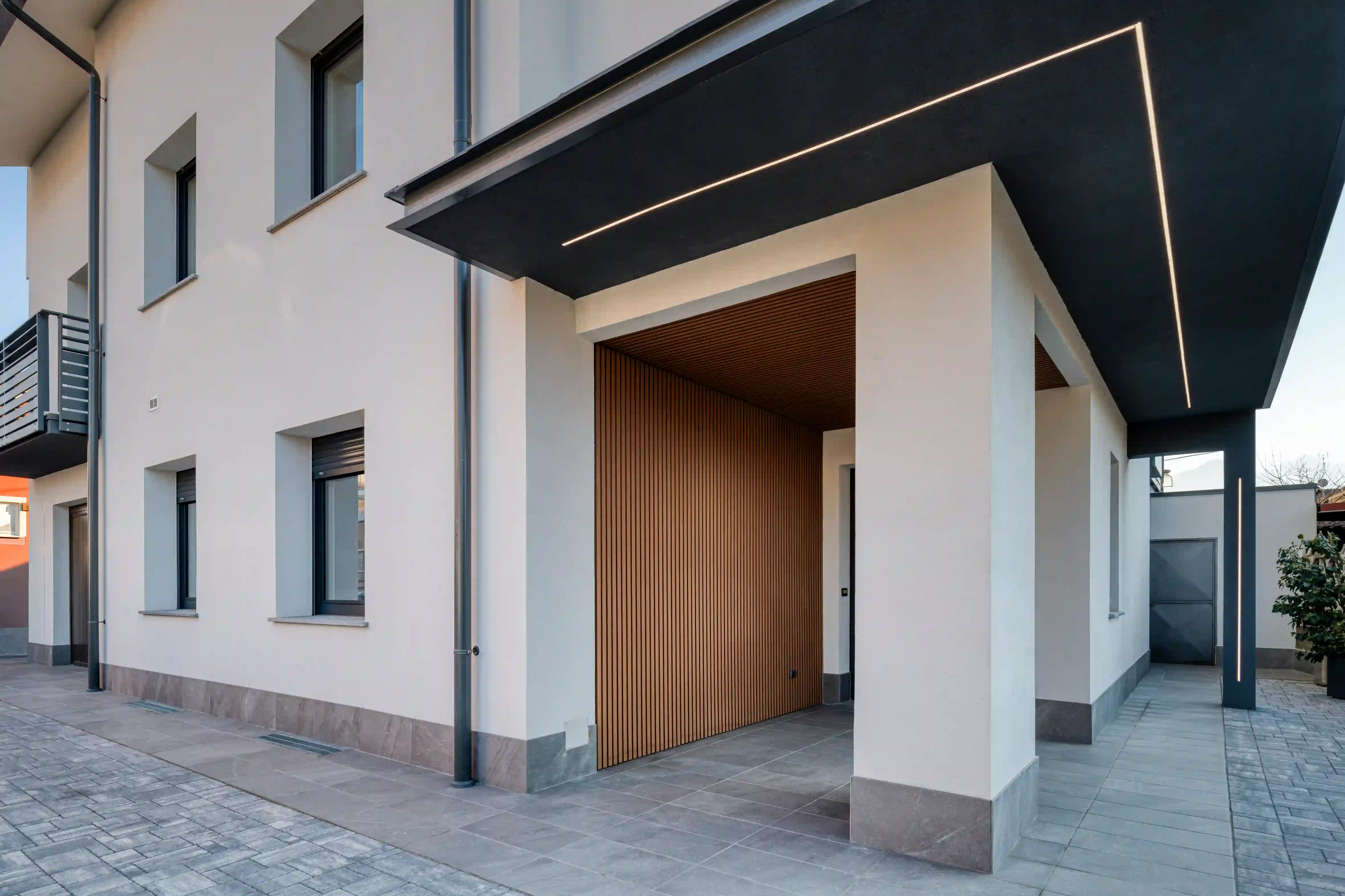05_immagine_progetto_casa_fascione Portico esterno con rivestimento in legno e pilastri bianchi