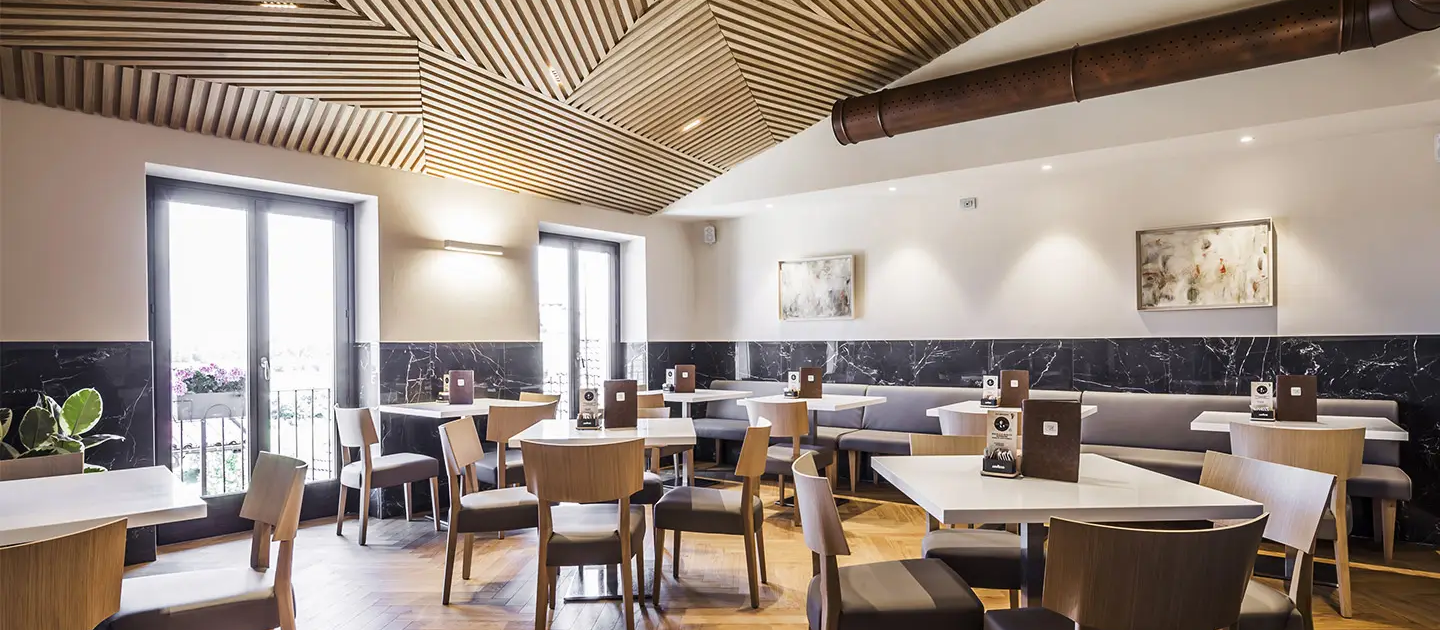05_immagine_progetto_la_chiocciola_degli_angeli sala ristorante con controsoffitto in listelli di legno a motivi geometrici in marmo scuro
