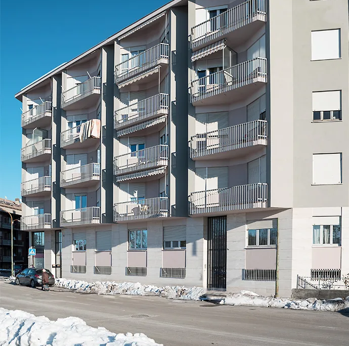 edificio residenziale moderno lungo strada urbana con balconi e facciata chiara