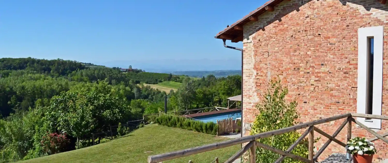 casale con piscina panoramica e vista sulle colline verdi e natura circostante