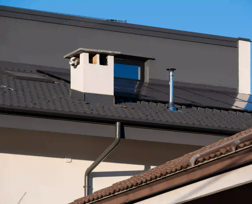 06_immagine_progetto_casa_fascione Tetto con pannelli fotovoltaici e comignolo su abitazione moderna