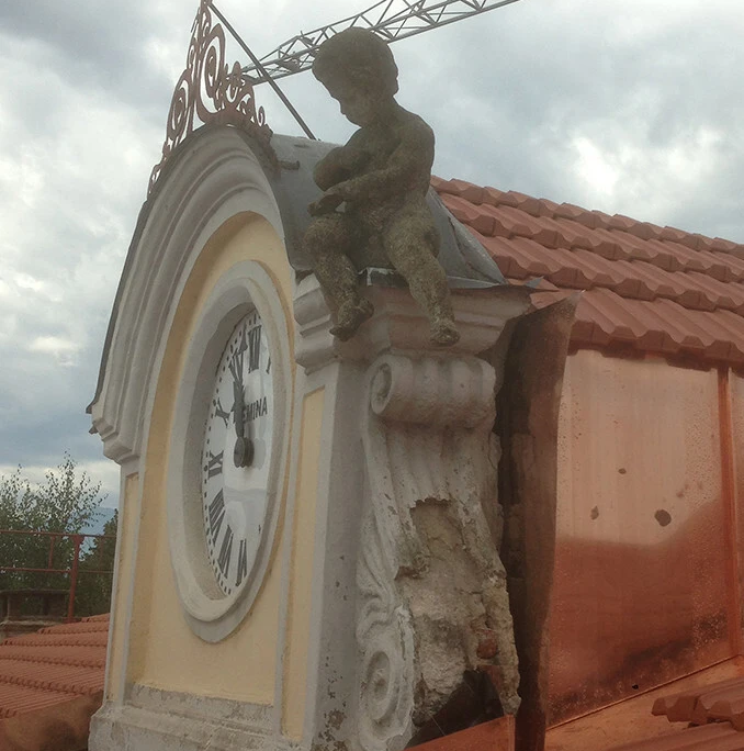 dettaglio deteriorato di orologio su facciata prima del restauro