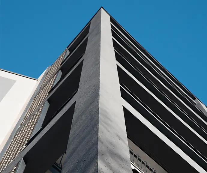 06_immagine_progetto_v_lotto spigolo dell'edificio con rivestimento scuro e successione prospettica dei balconi