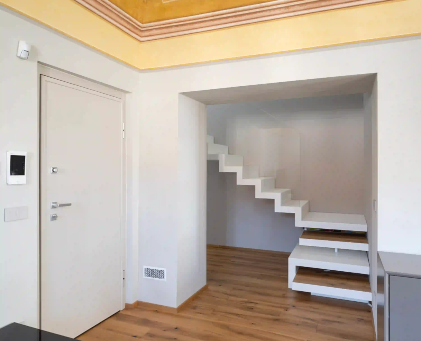 corridoio d'ingresso con soffitto decorato da affreschi floreali, pavimento in parquet e scala moderna a sbalzo