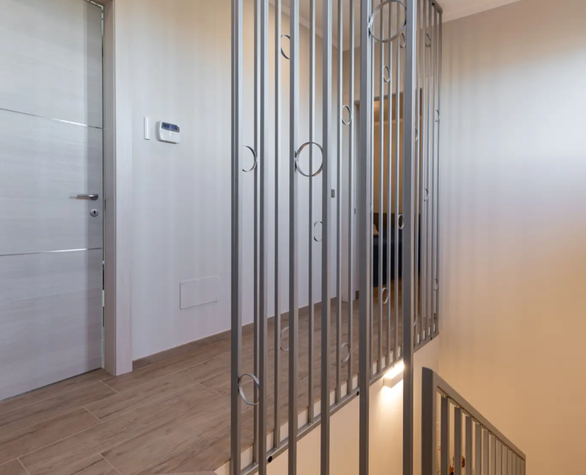 scala interna con parapetto in metallo dal design geometrico e finiture contemporanee
