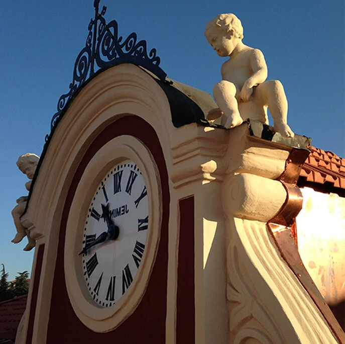 dettaglio restaurato di orologio decorativo con statue e finiture architettoniche