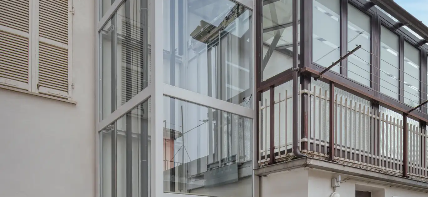 ascensore panoramico in vetro installato all’esterno di una casa con accesso al piano terra
