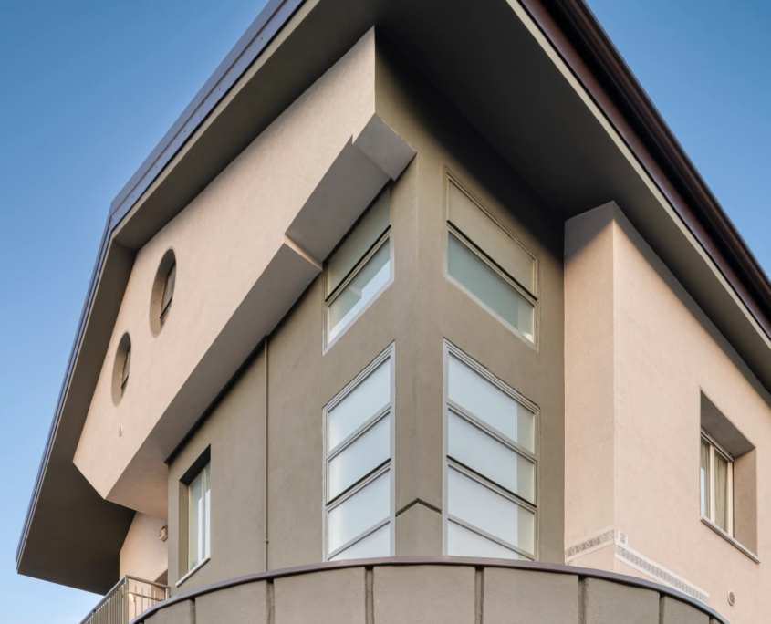 dettaglio architettonico dell'ingresso con pensilina circolare, vetrate a nastro e porta esterna moderna